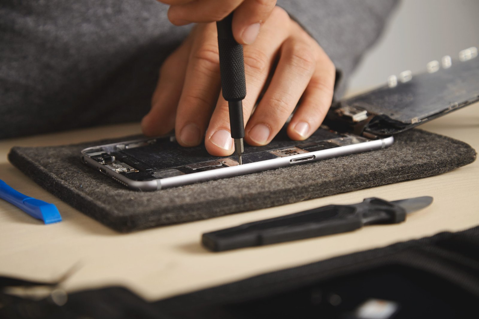 Technician performing battery replacement with transparent iPhone repair price Malaysia